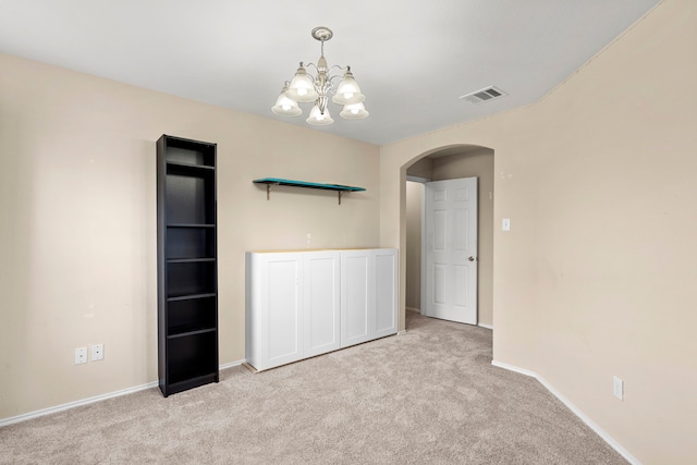 unfurnished room with light colored carpet and a chandelier