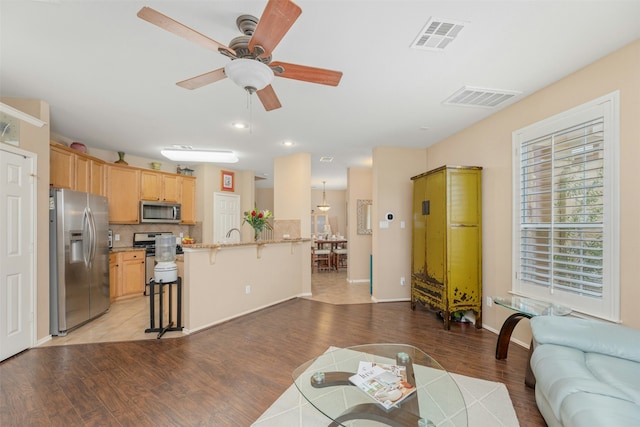 living room with ceiling fan and light hardwood / wood-style flooring