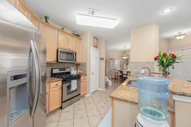 kitchen featuring kitchen peninsula, appliances with stainless steel finishes, tasteful backsplash, light brown cabinetry, and sink