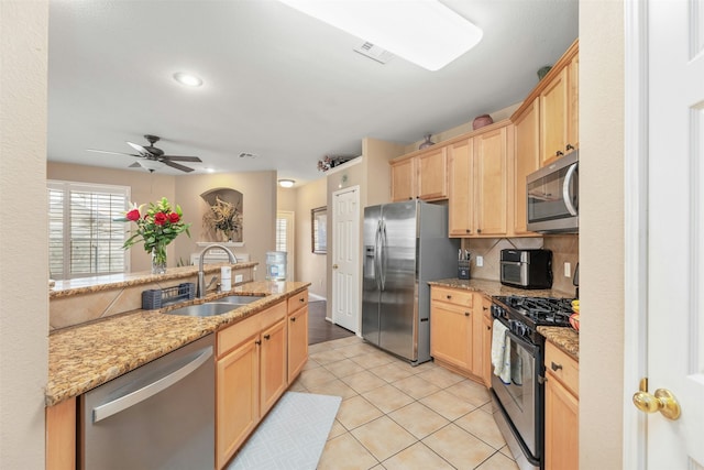 kitchen featuring light tile patterned floors, stainless steel appliances, tasteful backsplash, light stone countertops, and sink