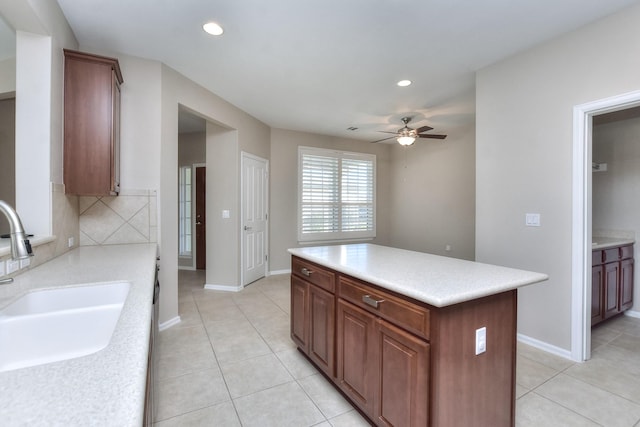 kitchen with a center island, tasteful backsplash, sink, ceiling fan, and light tile patterned floors