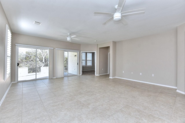 tiled spare room with ceiling fan and a healthy amount of sunlight