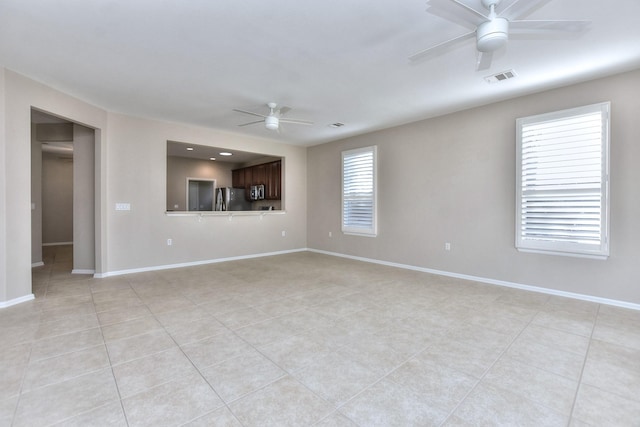 unfurnished living room with ceiling fan, plenty of natural light, and light tile patterned floors