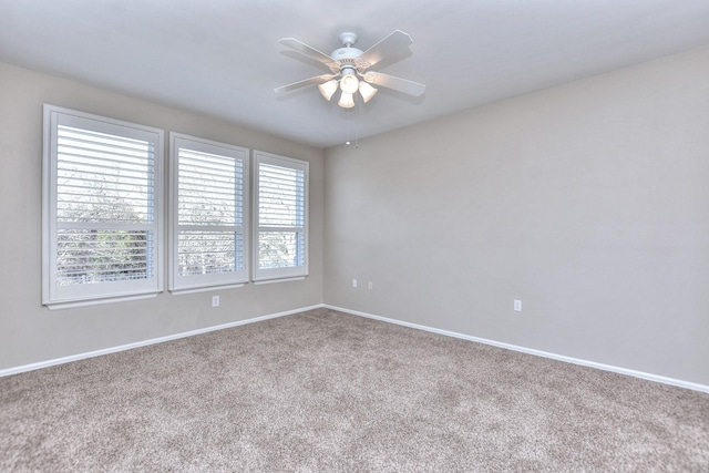 carpeted spare room featuring ceiling fan