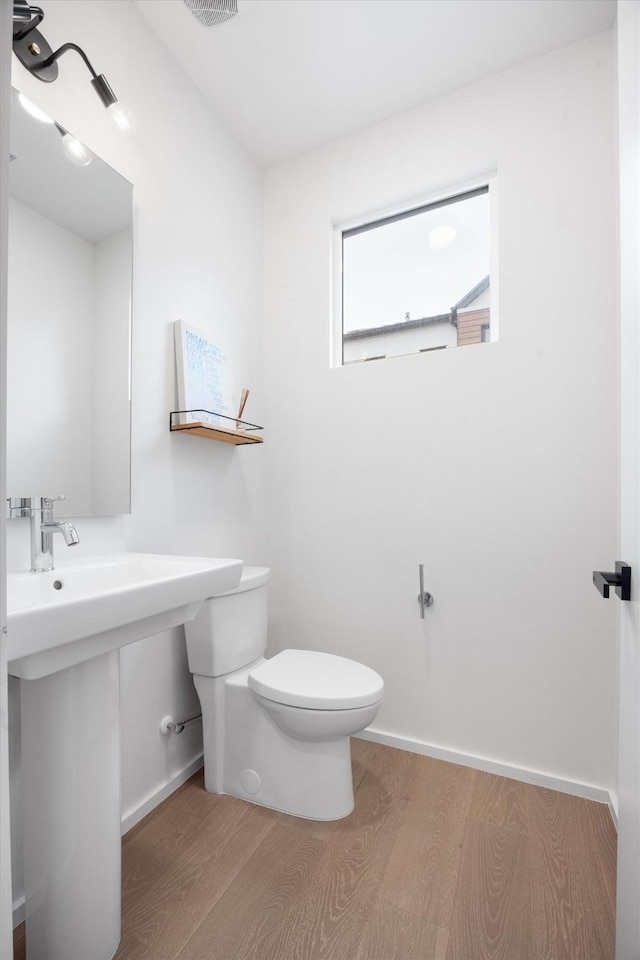 bathroom with toilet and hardwood / wood-style floors