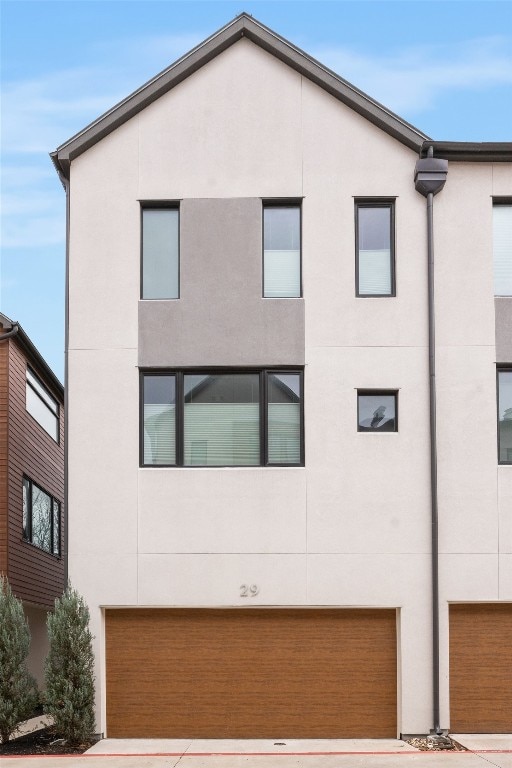 3100 Menchaca Rd Unit 29, Austin, TX 78704 - view of front of house with stucco siding, an attached garage, and driveway