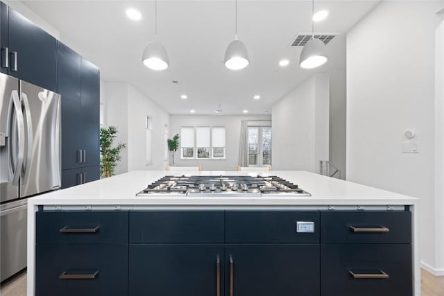 3100 Menchaca Rd Unit 29, Austin, TX 78704 - kitchen featuring appliances with stainless steel finishes, blue cabinetry, light countertops, a kitchen island, and modern cabinets
