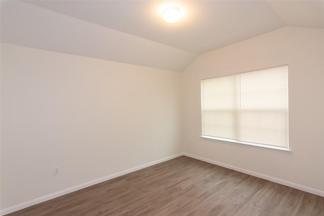 spare room with lofted ceiling and wood-type flooring