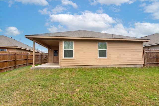 rear view of property featuring a patio area and a yard