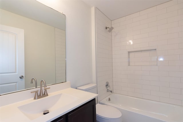 full bathroom featuring toilet, tiled shower / bath, and vanity