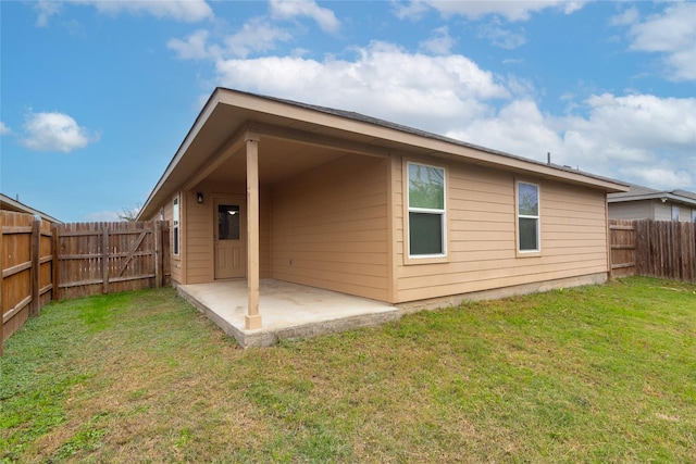 rear view of property featuring a yard and a patio