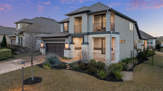 view of front of property with a lawn, a balcony, and a garage