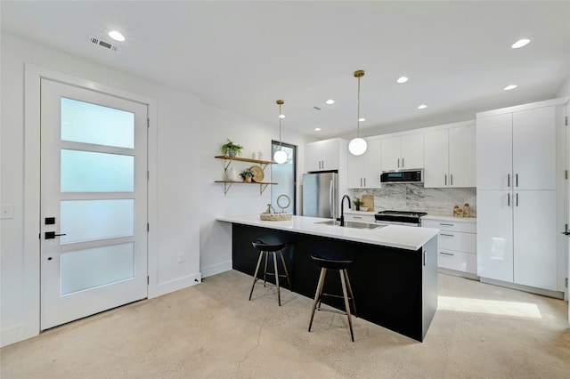 kitchen featuring pendant lighting, sink, stainless steel appliances, and white cabinets