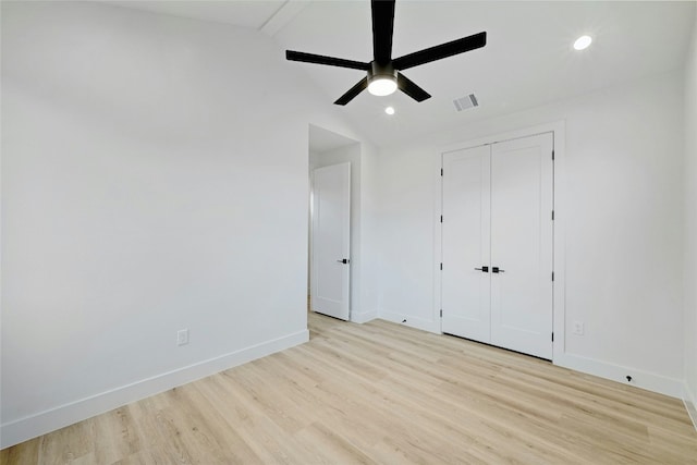 unfurnished bedroom featuring ceiling fan, lofted ceiling, a closet, and light hardwood / wood-style flooring