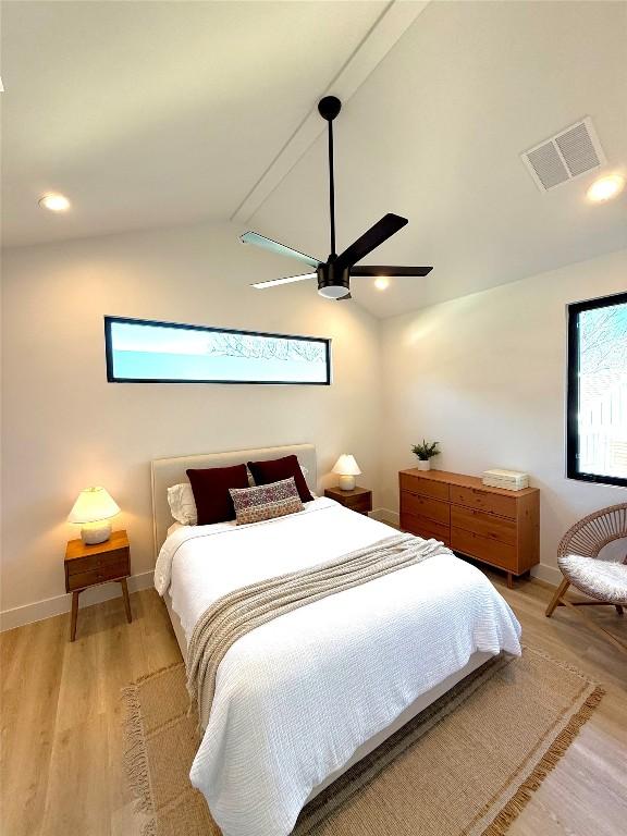 bedroom featuring lofted ceiling with beams, ceiling fan, and light wood-type flooring