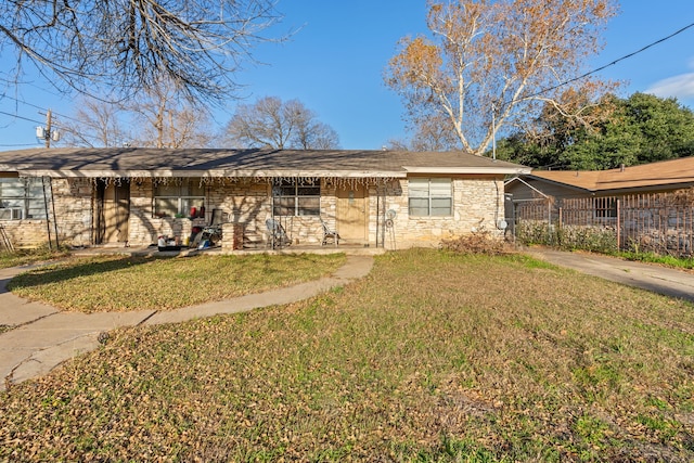 ranch-style house featuring covered porch and a front yard