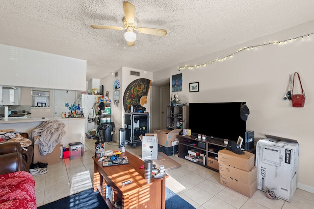 living room with ceiling fan, a textured ceiling, and light tile patterned floors