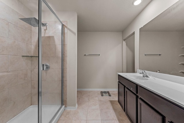 bathroom with a shower with shower door, vanity, and tile patterned flooring