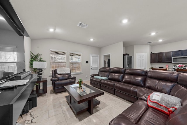 living room featuring vaulted ceiling and light tile patterned flooring