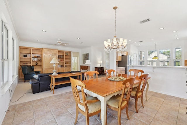 tiled dining space with ceiling fan with notable chandelier and ornamental molding