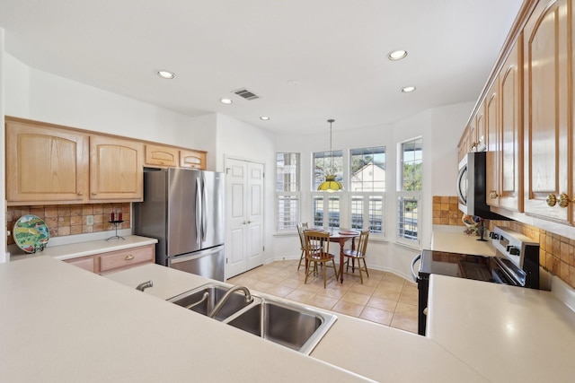 kitchen with pendant lighting, light tile patterned floors, backsplash, stainless steel appliances, and light brown cabinetry