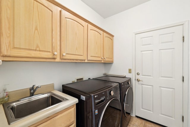 laundry area featuring light tile patterned flooring, cabinets, separate washer and dryer, and sink