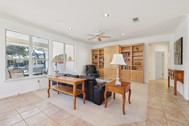 living room with light tile patterned floors, crown molding, and ceiling fan