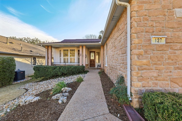 entrance to property with cooling unit and covered porch