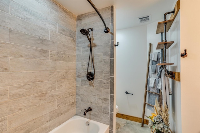 bathroom featuring toilet and tiled shower / bath combo