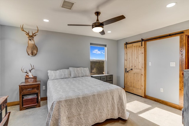 bedroom with ceiling fan and a barn door