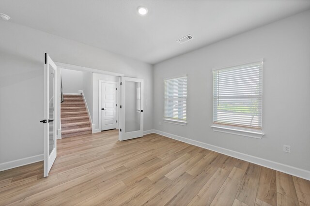 empty room with light wood-type flooring and french doors