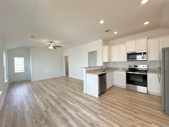 kitchen with kitchen peninsula, stainless steel appliances, white cabinets, and sink