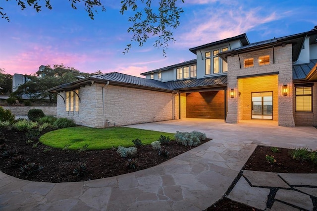 back house at dusk with a garage