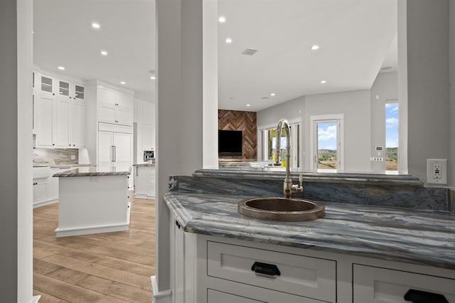 kitchen featuring white cabinetry, dark stone countertops, and kitchen peninsula