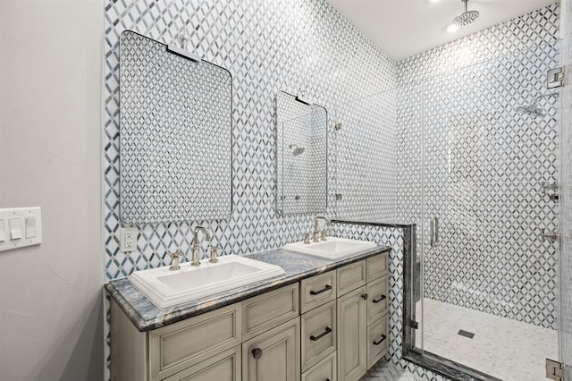 bathroom featuring a shower with shower door and vanity