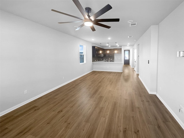 unfurnished living room with ceiling fan and dark hardwood / wood-style floors