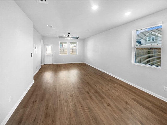 unfurnished living room featuring ceiling fan and dark wood-type flooring