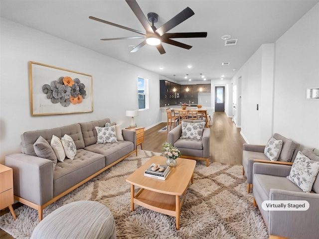 living room featuring ceiling fan and wood-type flooring