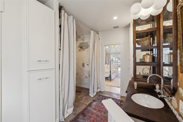 bathroom featuring walk in shower and vanity