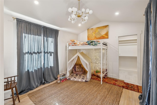 bedroom featuring lofted ceiling, a notable chandelier, and hardwood / wood-style floors