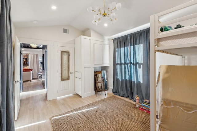 bedroom featuring light hardwood / wood-style flooring, a notable chandelier, and vaulted ceiling