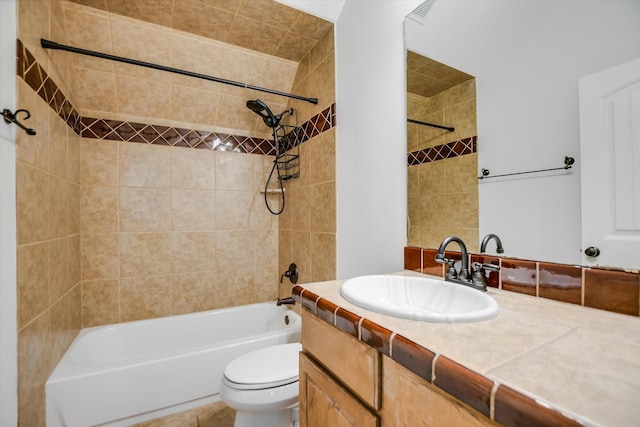 full bathroom featuring toilet, tiled shower / bath combo, and vanity