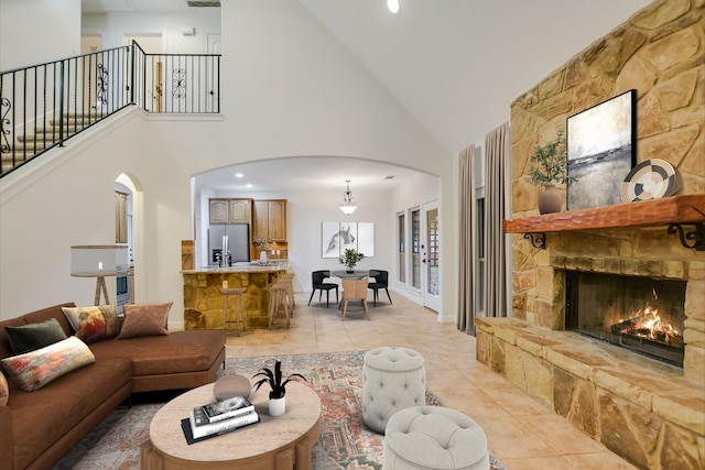 living room featuring light tile patterned flooring, a fireplace, and high vaulted ceiling