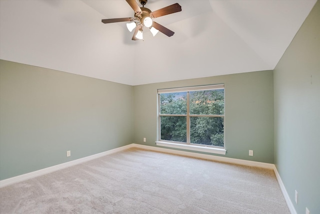 empty room featuring ceiling fan, vaulted ceiling, and carpet flooring