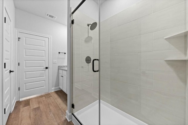 bathroom with vanity, an enclosed shower, and hardwood / wood-style floors