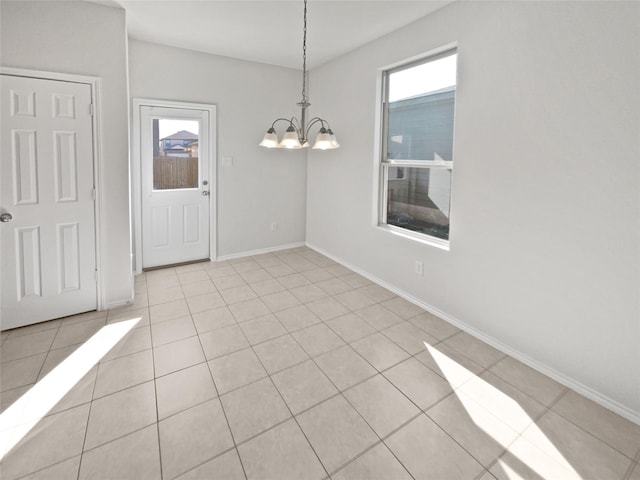 unfurnished dining area featuring a healthy amount of sunlight, light tile patterned flooring, and a chandelier