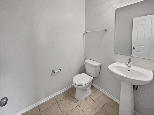 bathroom with toilet and tile patterned floors