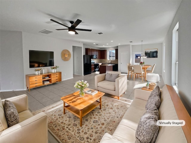 living room with ceiling fan, light tile patterned floors, and a wealth of natural light