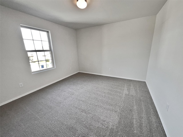 spare room featuring dark carpet