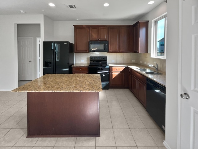 kitchen with tasteful backsplash, light tile patterned flooring, a kitchen island, black appliances, and sink